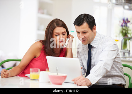 Couple Looking at Laptop Over Breakfast Stock Photo