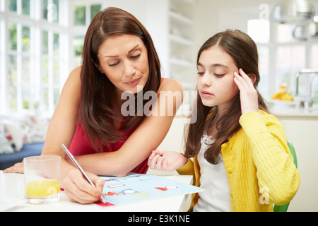 Mother Helping Daughter Struggling With Homework Stock Photo