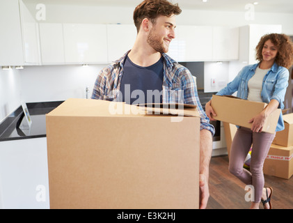 Couple Moving Into New Home And Unpacking Boxes Stock Photo