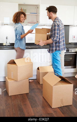 Couple Moving Into New Home And Unpacking Boxes Stock Photo