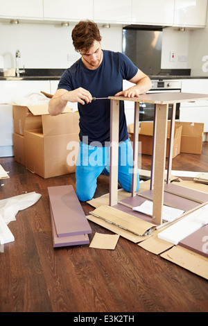 Man Putting Together Self Assembly Furniture In New Home Stock Photo