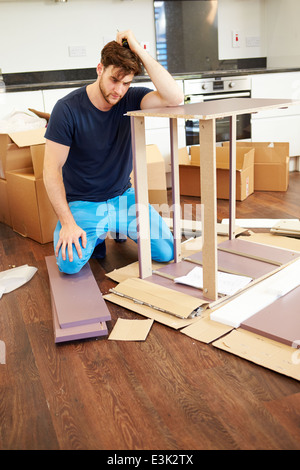 Frustrated Man Putting Together Self Assembly Furniture Stock Photo
