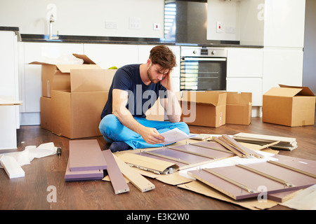 Frustrated Man Putting Together Self Assembly Furniture Stock Photo