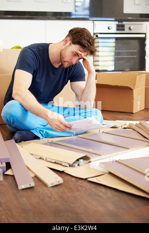 Frustrated Man Putting Together Self Assembly Furniture Stock Photo