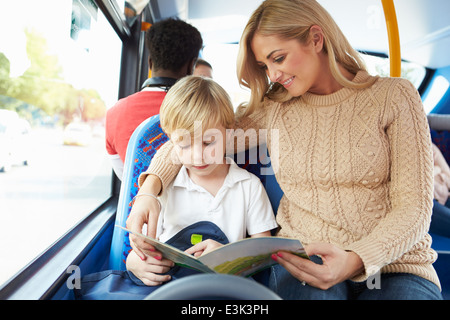 Mother And Son Going To School On Bus Together Stock Photo