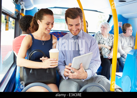Businessman And Woman Using Digital Tablet On Bus Stock Photo