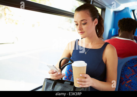 Businesswoman Sending Text Message On Bus Stock Photo