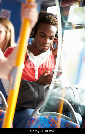 Man Wearing Headphones Listening To Music On Bus Journey Stock Photo
