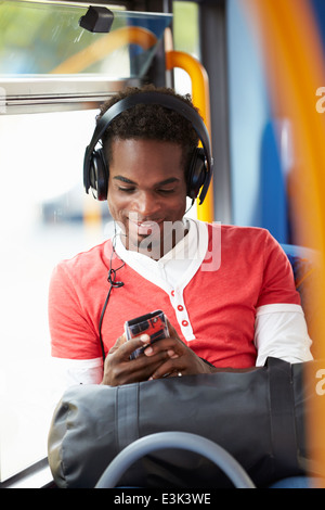 Man Wearing Headphones Listening To Music On Bus Journey Stock Photo