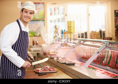 Butcher cutting meat in his shop in the Jewish quarter of Krakow ...