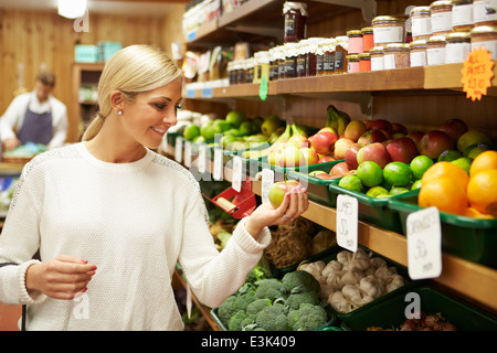 Female Customer At Vegetable Counter Of Farm Shop Stock Photo