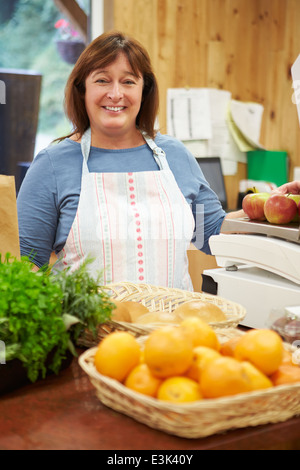 Female Sales Assistant At Checkout Of Farm Shop Stock Photo