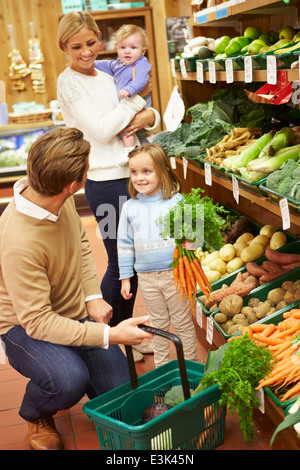 Family Choosing Fresh Vegetables In Farm Shop Stock Photo