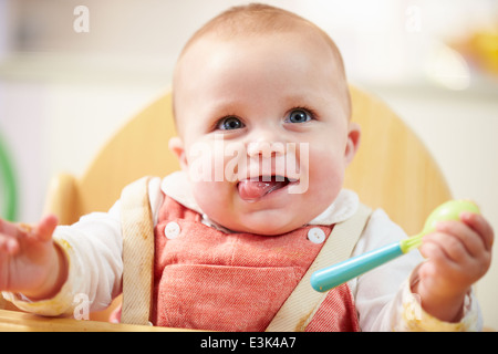 Portrait Of Happy Young Baby Boy In High Chair Stock Photo