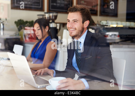 Businessman Using Laptop In Coffee Shop Stock Photo