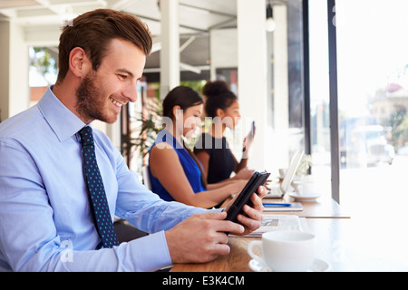 Businessman Using Digital Tablet In Coffee Shop Stock Photo