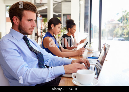Businessman Using Laptop In Coffee Shop Stock Photo