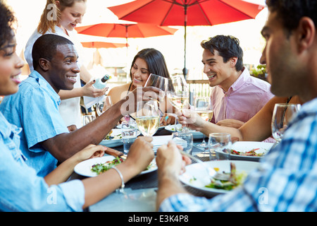 Group Of Friends Enjoying Meal At Outdoor Restaurant Stock Photo