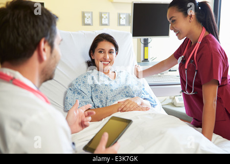 Medical Team Meeting With Woman In Hospital Room Stock Photo