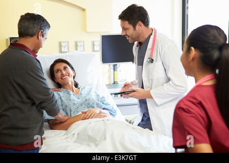 Medical Team Meeting With Couple In Hospital Room Stock Photo