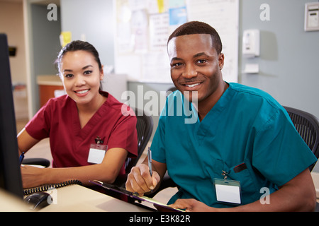 Male And Female Nurse Working At Nurses Station Stock Photo