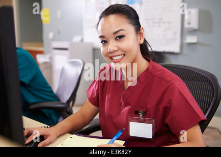 Portrait Of Female Nurse Working At Nurses Station Stock Photo