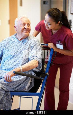 Senior Male Patient Being Pushed In Wheelchair By Nurse Stock Photo