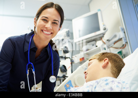 Female Consultant With Sleeping Patient In Emergency Room Stock Photo