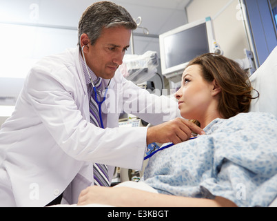 Male Doctor Examining Female Patient In Emergency Room Stock Photo