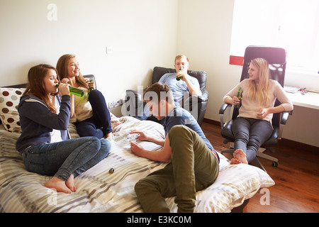 Group Of Teenagers Drinking Alcohol In Bedroom Stock Photo