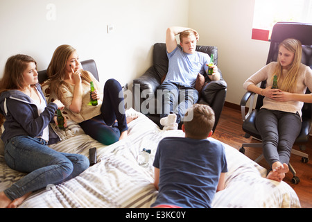 Group Of Teenagers Drinking Alcohol In Bedroom Stock Photo