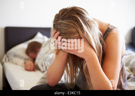 Worried Teenage Girl In Bedroom With Boyfriend Stock Photo