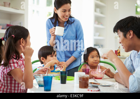 Asian Family Having Breakfast Together In Kitchen Stock Photo