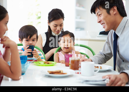 Asian Family Having Breakfast Before Husband Goes To Work Stock Photo