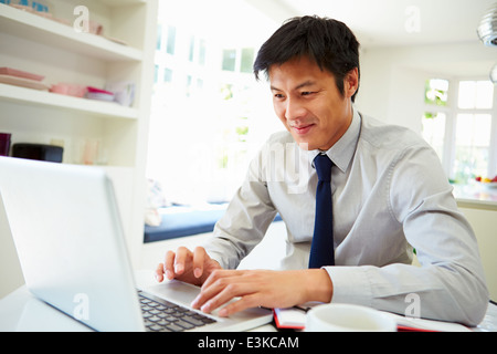 Asian Businessman Working From Home On Laptop Stock Photo