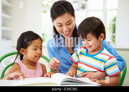 Mother Helping Children With Homework Stock Photo