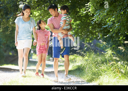 Asian Family Enjoying Walk In Countryside Stock Photo
