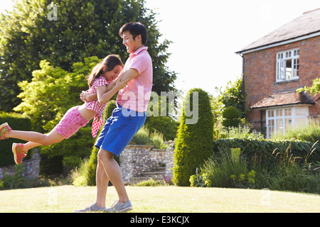 Asian Father And Daughter Playing In Summer Garden Together Stock Photo
