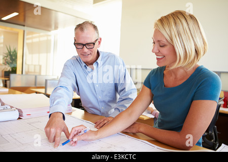 Architects Studying Plans In Modern Office Together Stock Photo