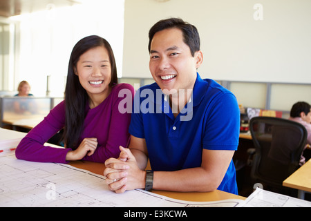 Architects Studying Plans In Modern Office Together Stock Photo