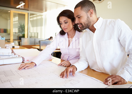 Architects Studying Plans In Modern Office Together Stock Photo