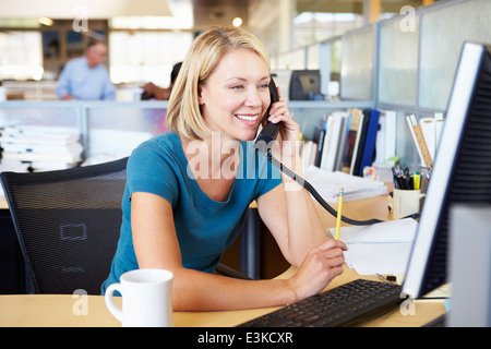Woman On Phone In Busy Modern Office Stock Photo