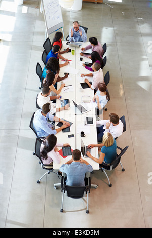 Businessman Addressing Meeting Around Boardroom Table Stock Photo