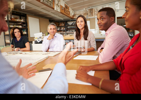 Six Architects Sitting Around Table Having Meeting Stock Photo