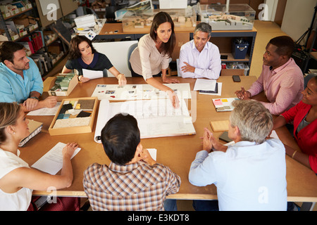 Female Boss Leading Meeting Of Architects Sitting At Table Stock Photo