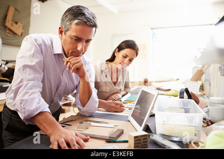 Two Architects Making Models In Office Using Digital Tablet Stock Photo