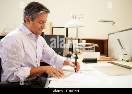Male Architect Working At Desk In Office Stock Photo