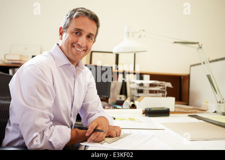 Male Architect Working At Desk In Office Stock Photo