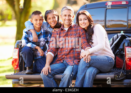 Family Sitting In Pick Up Truck On Camping Holiday Stock Photo