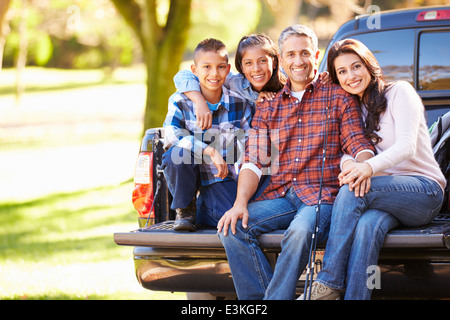 Family Sitting In Pick Up Truck On Camping Holiday Stock Photo